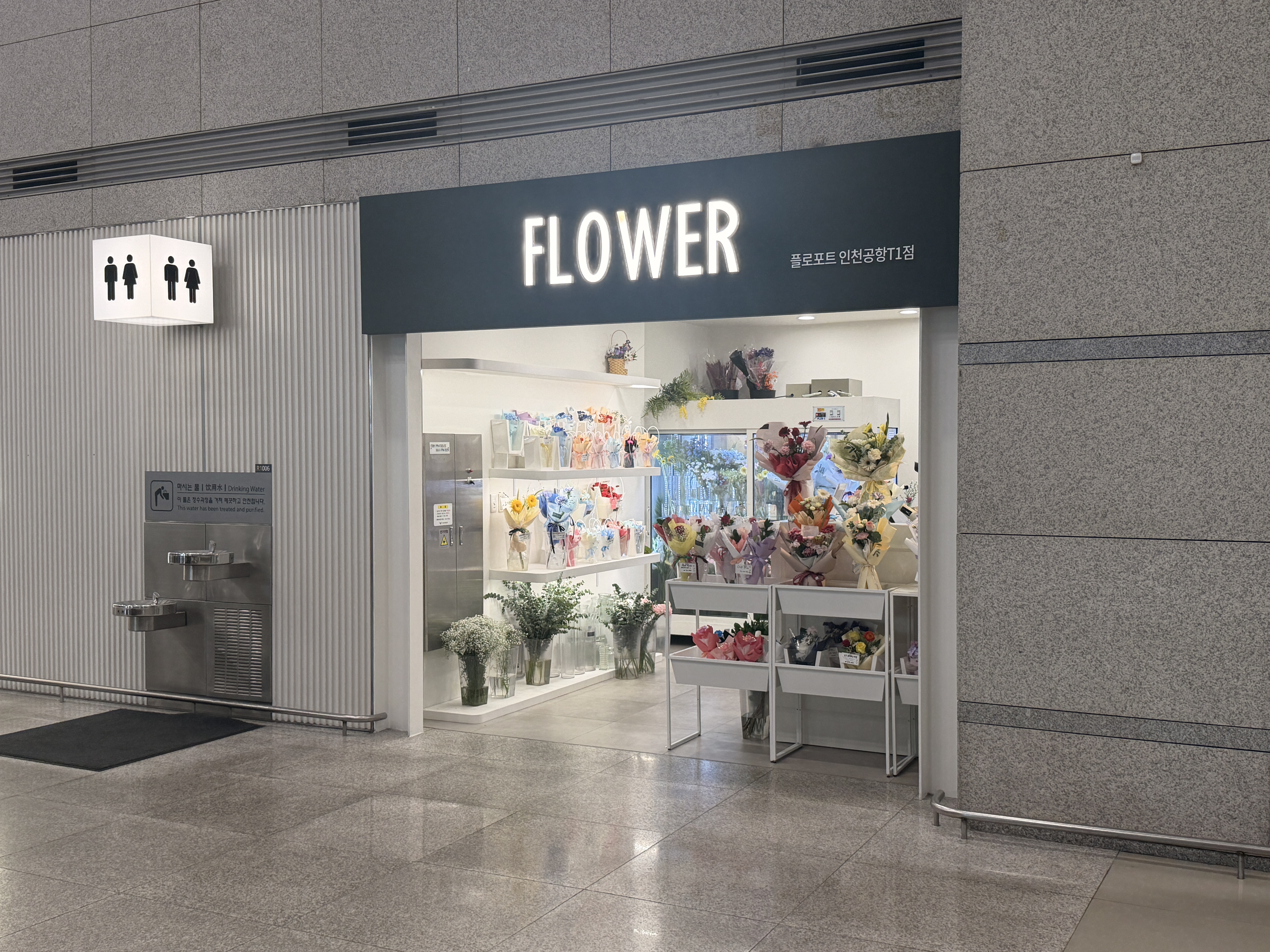 Floport flower shop next to restroom and water fountain at Incheon Airport