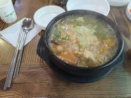 Gaeseong sanghwang mushroom samgyetang — golden medicinal broth in a black pot