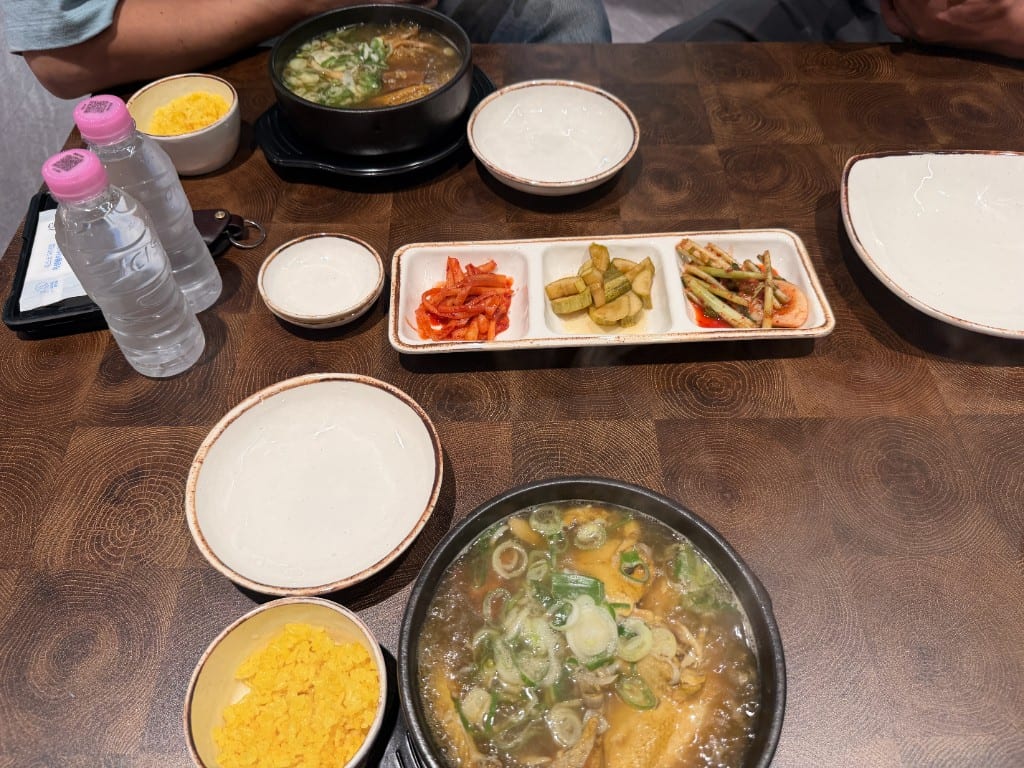 Two bowls of Taebaek sanghwang samgyetang with yellow rice on a wood-grain table