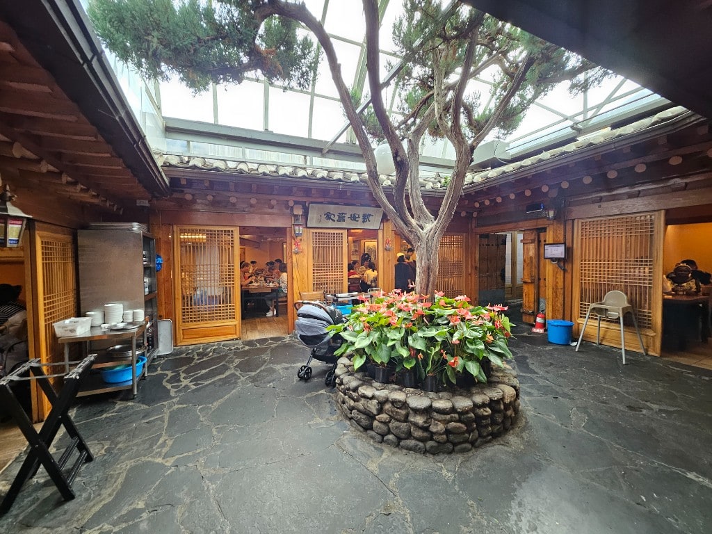 Tosokchon courtyard — a hanok interior with rooms around a tree and stone flooring