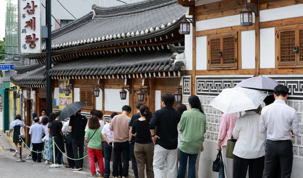 Queue waiting outside Tosokchon Samgyetang under the hanok eaves around Bok-nal